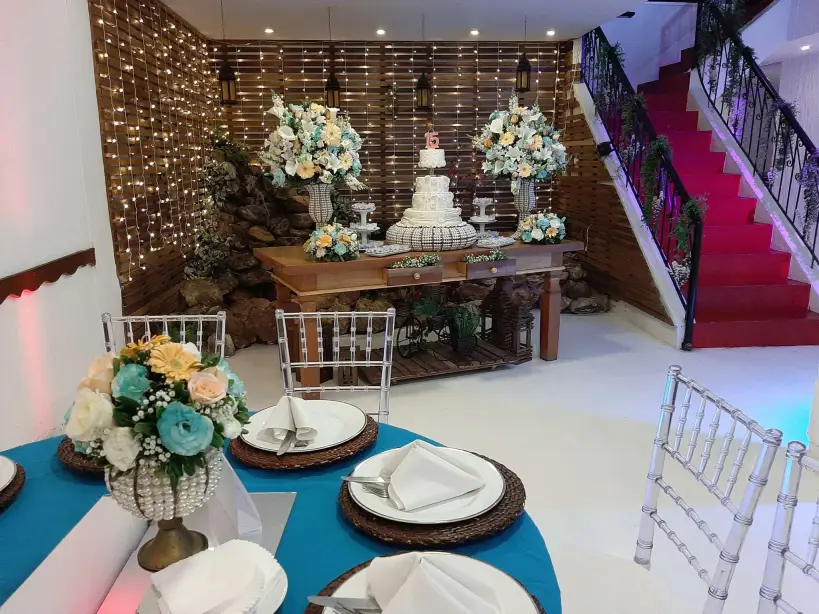 Salão montado para festa de 15 anos com mesa do bolo