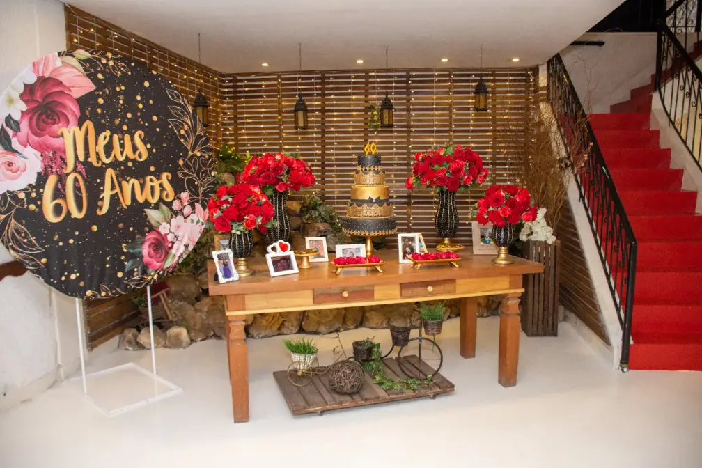 Mesa de aniversário de 60 anos decorada com rosas vermelhas